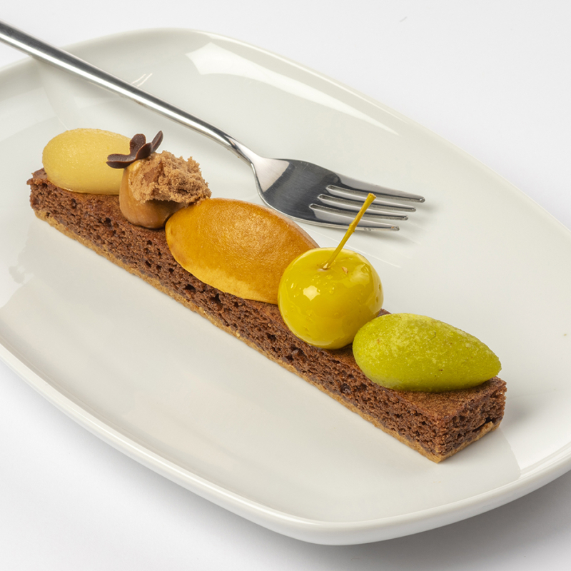 Herfstplankje met peer, appeltje, grote caramelmousse, puntje hazelnootpraliné, kleine canelle appel en puntje peer